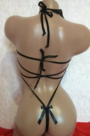 Mannequin wearing a black strappy outfit with red fabric at the base.