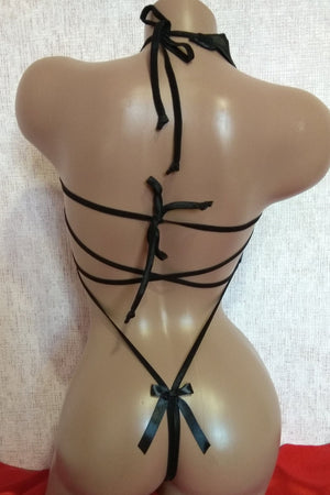 Mannequin wearing a black strappy outfit with red fabric at the base.