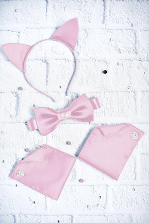 Pink cat ears, bow tie, and tail set on a white brick background