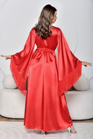 Woman wearing a red satin dress with fringe details in a minimalistic setting.
