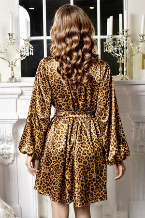 Person wearing a leopard print dress in a decorative room with candles and a mirror.
