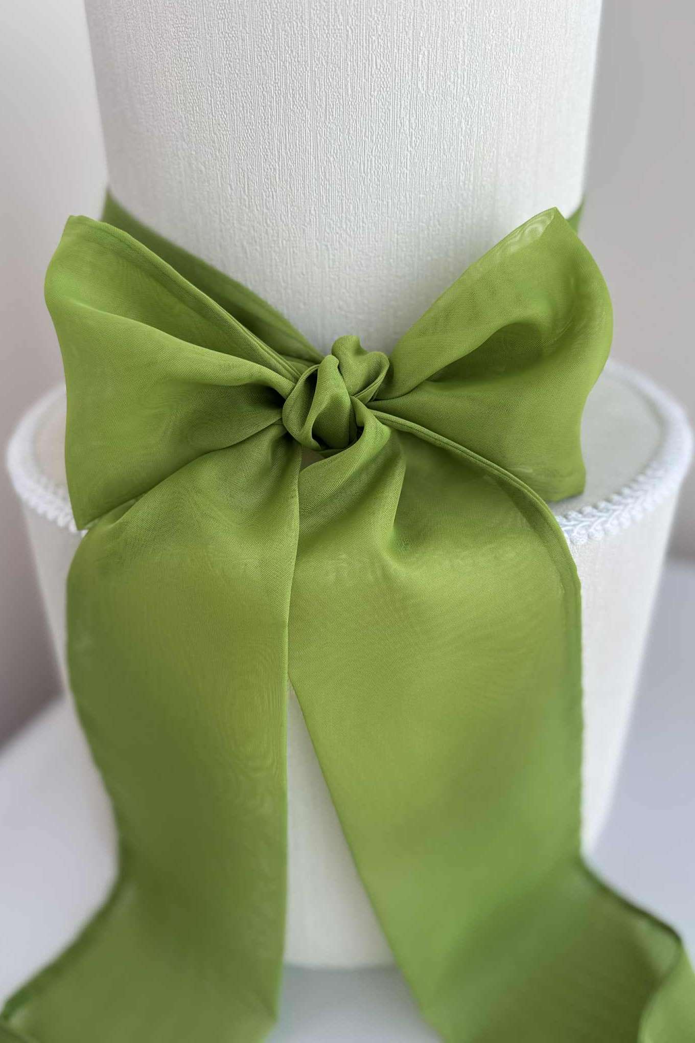 Green satin bow on a white mannequin head