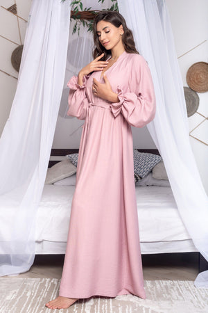 Woman wearing a pink robe in a bedroom setting