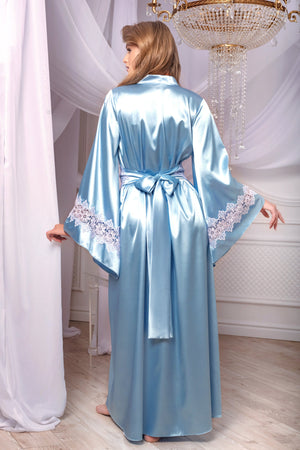Woman wearing a light blue satin robe with lace trim in a elegant room.