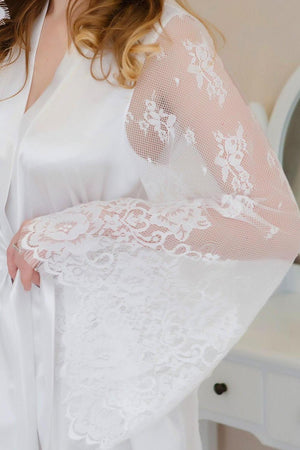 White lace garment held by a person with a neutral background
