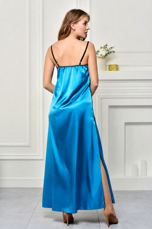 A woman wearing a bright blue satin slip dress with black spaghetti straps, shown from the back in a bright, white-paneled room.