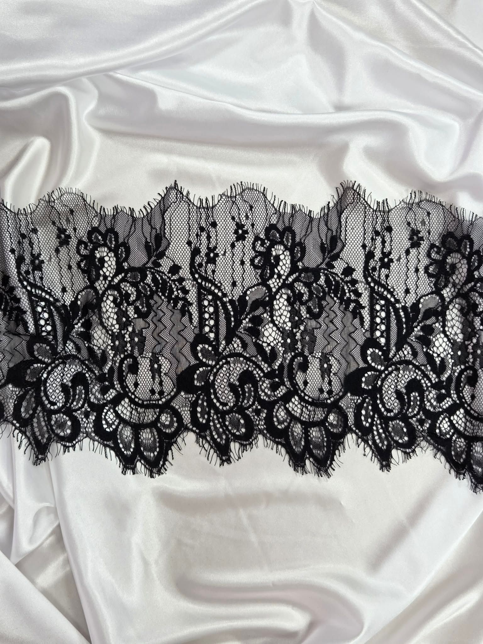 Black lace trim on satin fabric