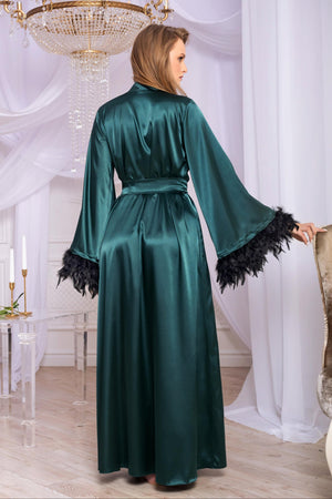 Woman wearing a green satin robe with black feather details in an elegant room.
