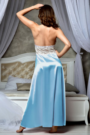 A woman stands barefoot in a bedroom wearing a strapless light blue satin maxi dress.