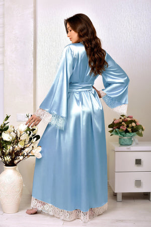 A woman wearing a light blue satin robe with white lace trim on the cuffs and hem