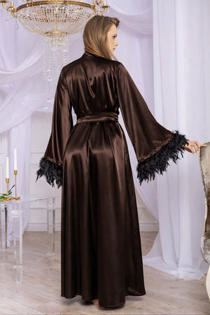 Woman wearing a brown satin robe with black feather trim in a elegant room.