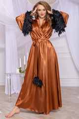 Woman wearing a long brown satin dress with black feathered sleeves in a decorated room.