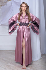 Woman wearing a pink satin robe with black lace details