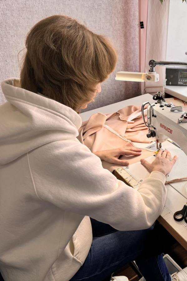 Person working on a sewing machine with a focus on the hands and machine