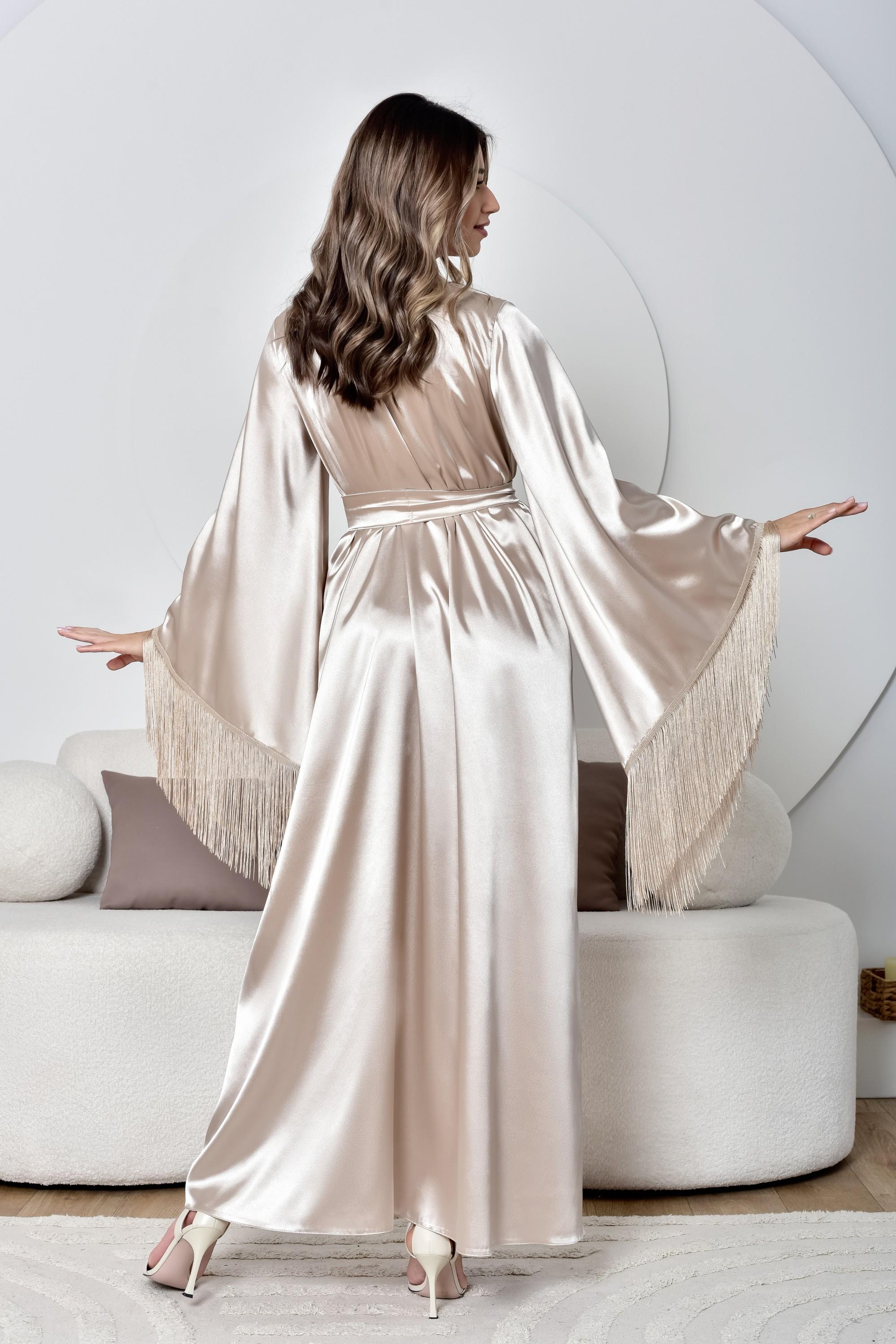 Woman wearing a long, light-colored satin robe in a modern room.