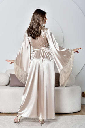 Woman wearing a long, light-colored satin robe in a modern room.