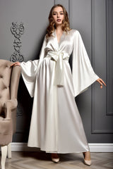 Woman wearing a ivory satin robe - luxe bridal kimono