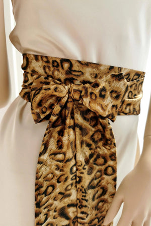 Leopard print belt tied around a waist with a plain background